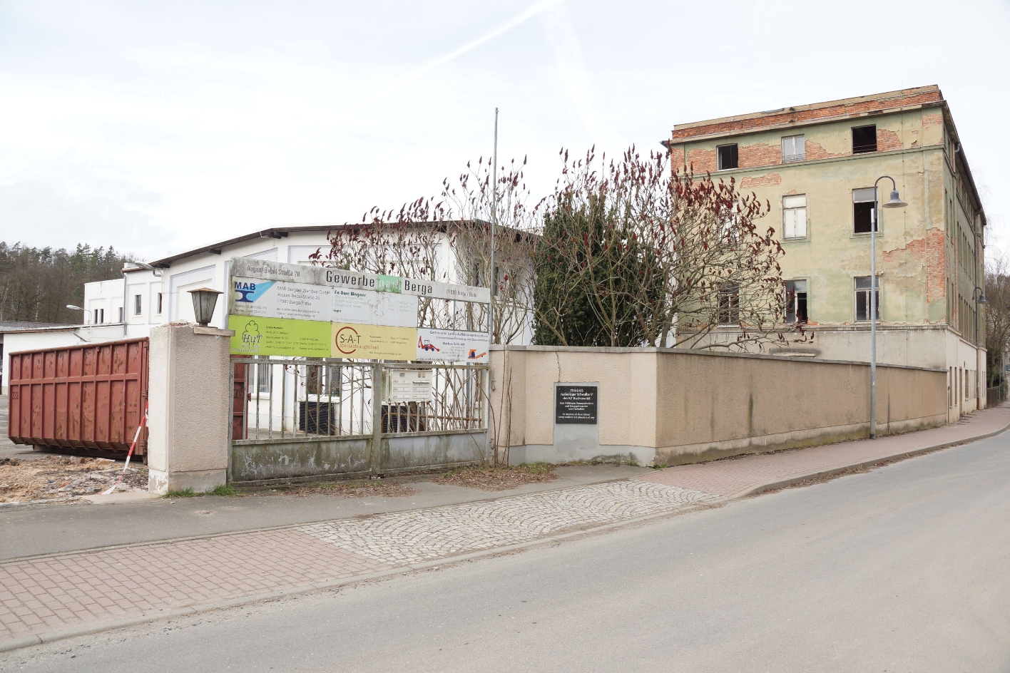 Gedenktafel am Eingang zum ehemaligen Lagergelände am heutigen Gewerbepark August-Bebel-Straße 20, 2022. Die Werkhalle befand sich links neben dem mehrstöckigen Gebäude. Foto: Katharina Brand