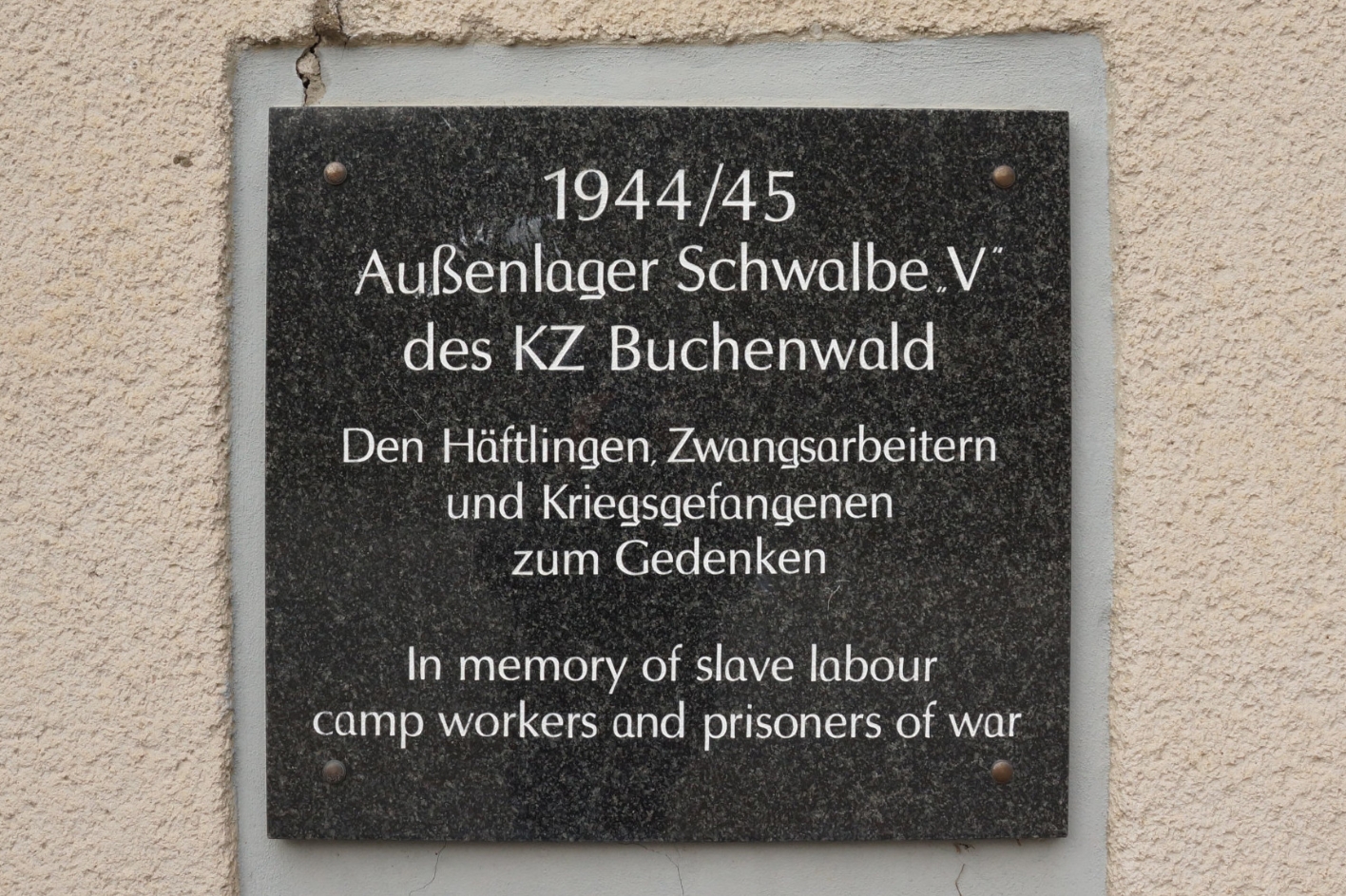 Gedenktafel am Eingang zum ehemaligen Lagergelände am heutigen Gewerbepark August-Bebel-Straße 20, 2022. Die Werkhalle befand sich links neben dem mehrstöckigen Gebäude. Foto: Katharina Brand
