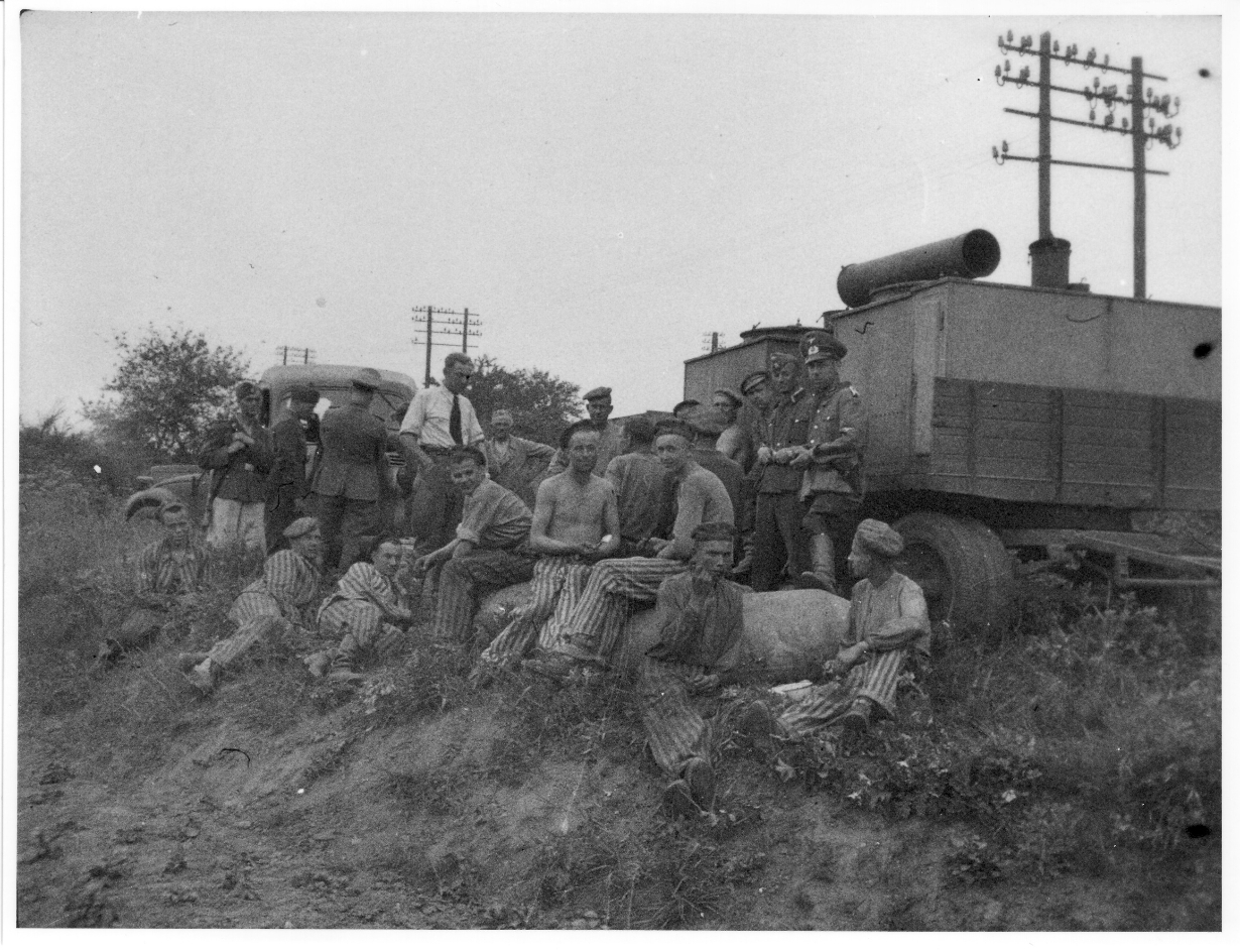 Häftlinge des Bombenräumkommandos „Kalkum“ mit Uniformierten und einer entschärften Bombe, 1943/44.
