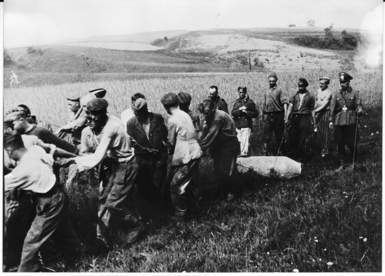 Häftlinge und Zuchthausinsassen des Bombenräumkommandos „Kalkum“ bei der Bergung einer Bombe, 1943/44. Bei dem Uniformierten handelt es sich vermutlich um einen Feuerwerker.
