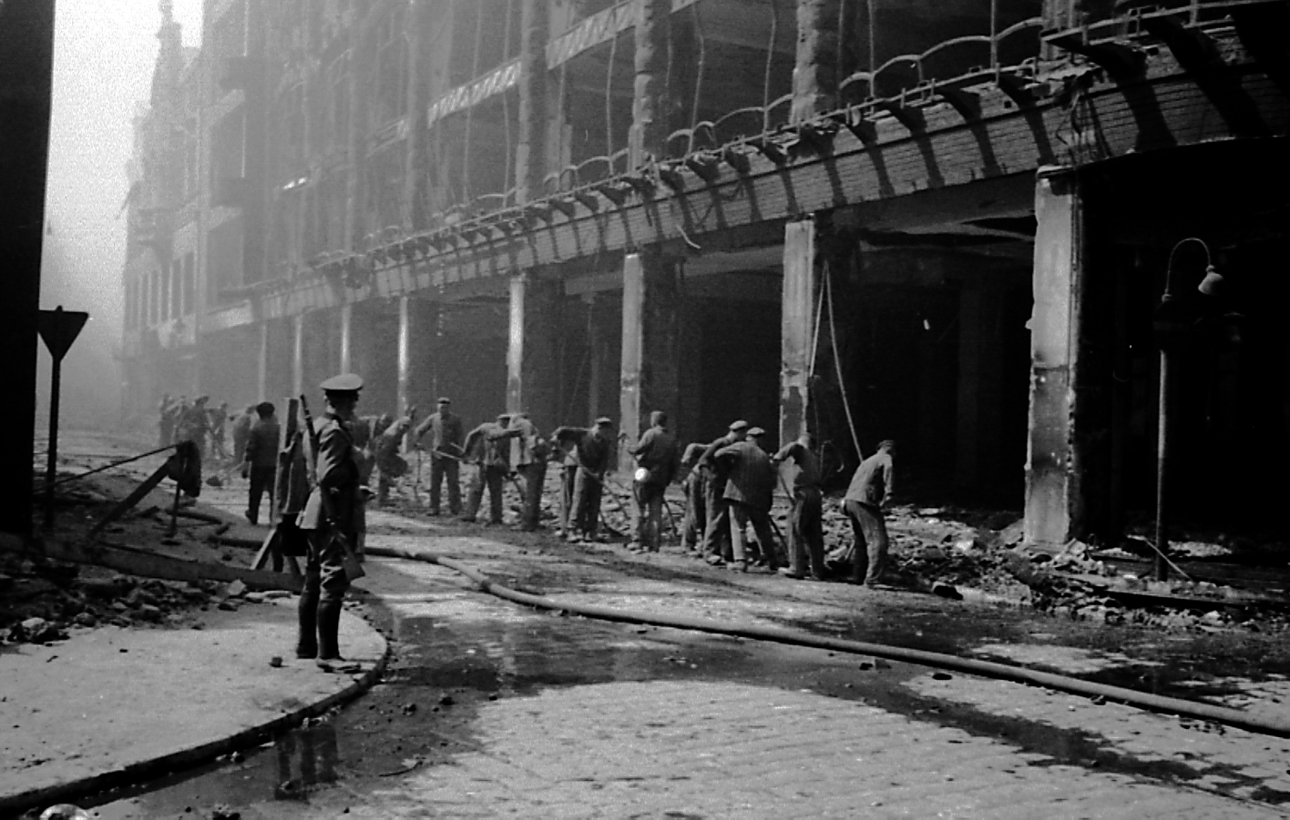 Arbeitende Häftlinge der SS-Baubrigade III und ihre Bewacher in der Duisburger Innenstadt, 1943. Das Foto machte der Duisburger Berufsfotograf Willy van Heekern.