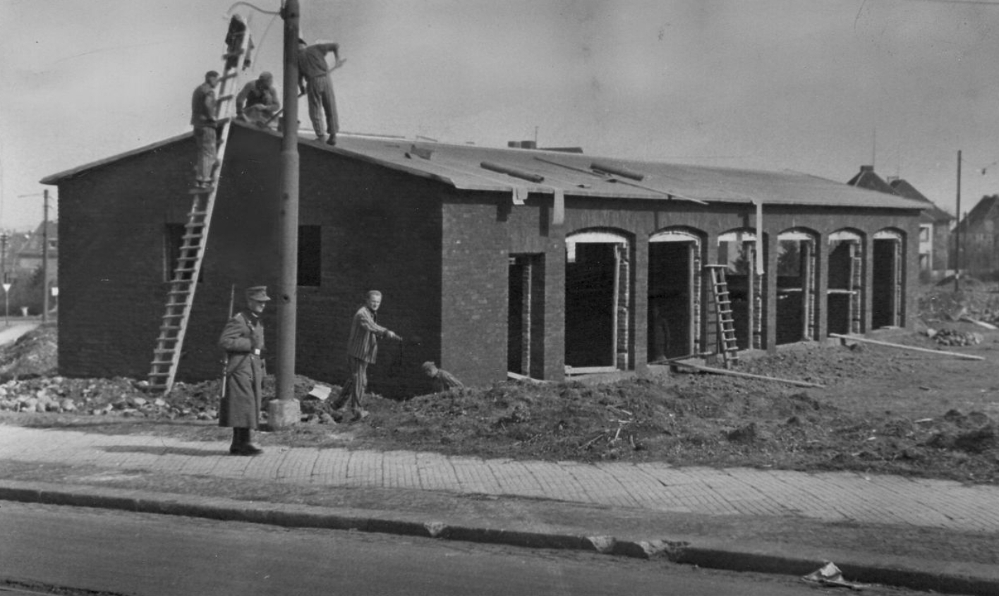Häftlinge und ein Wachmann (vermutlich ein Polizist) beim Bau einer Wagenhalle in der Straße „An den Eichen“, 1943