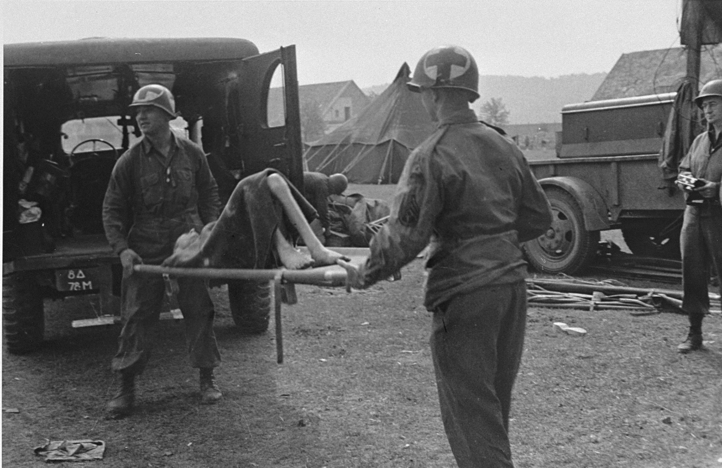 Sanitäter der U.S. Army bringen einen Überlebenden in das Notlazarett in Halberstadt, Mitte April 1945. Foto: Bernard Metrick