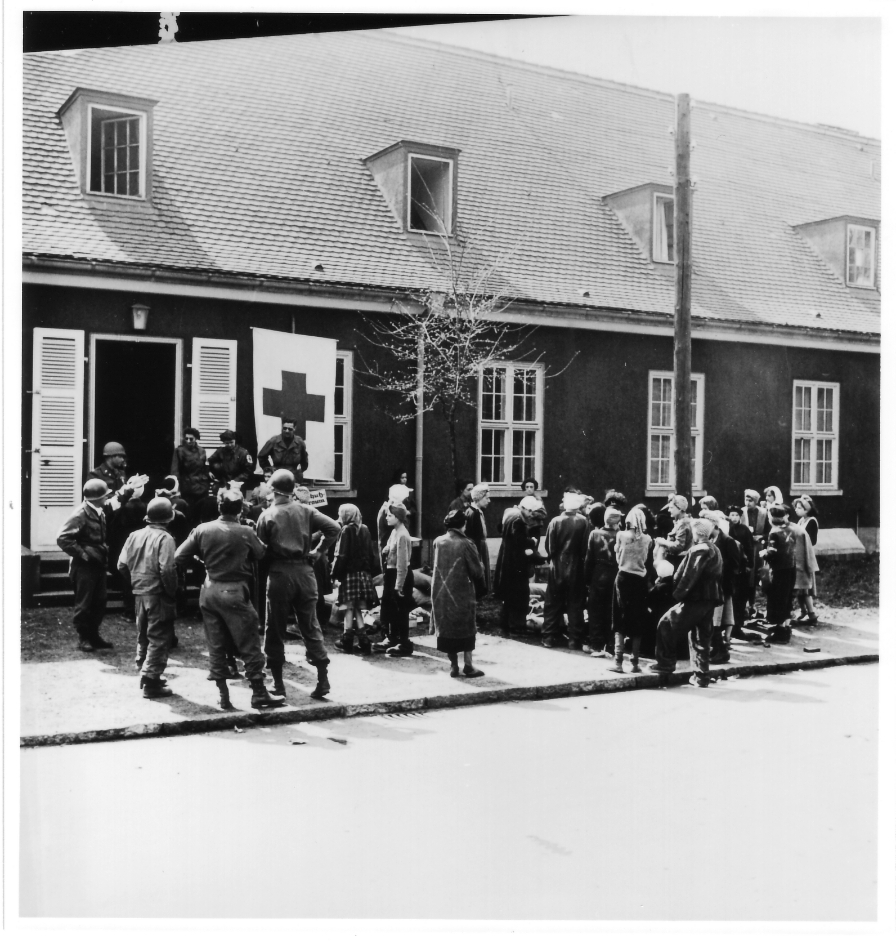 Überlebende und U.S.-Sanitäter vor dem ehemaligen Luftwaffenlazarett in Altenburg, 17. April 1945. Foto: David E. Scherman