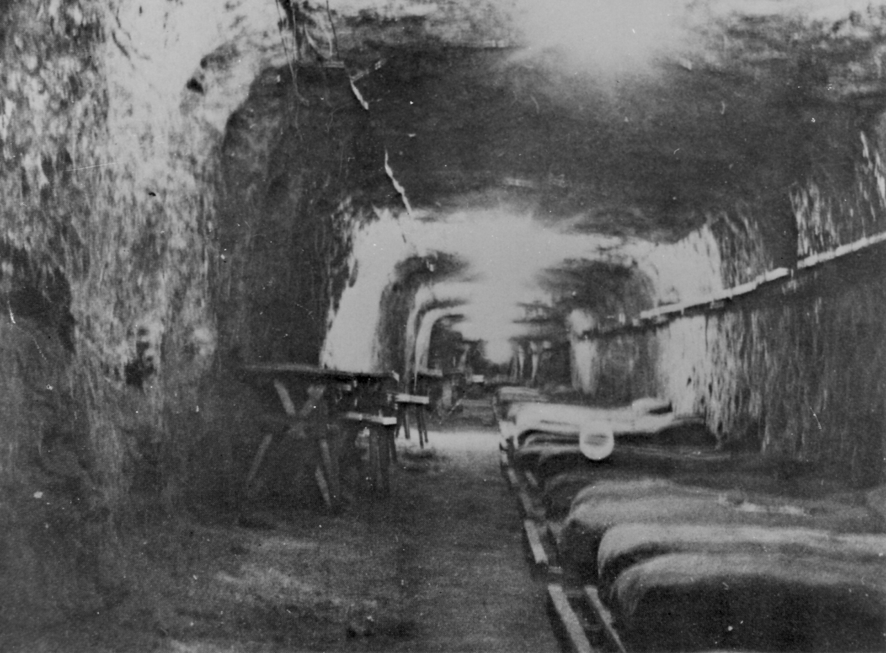 Schlafstollen mit Betten im Schacht „Gerhard“, wo Häftlinge vermutlich ab Februar 1945 untergebracht waren, April 1945 (nach der Befreiung). Foto: Gérard Raphaël Algoet