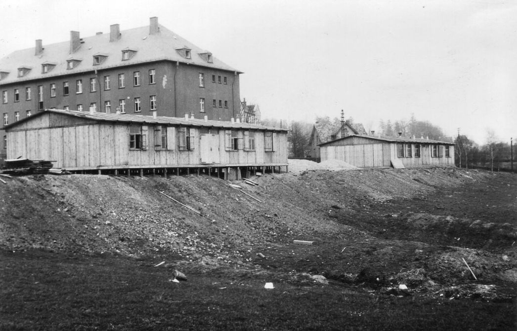 Zwei von Häftlingen gebaute Unterrichtsbaracken der SS-Führerschule (heutige Schlesienstraße). Im Hintergrund eine ehemalige Mannschaftskaserne (Block D), 1944/1945