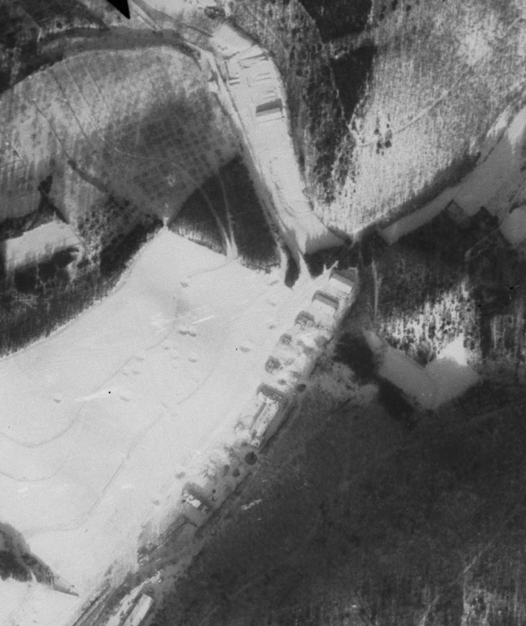 Vergrößerter Ausschnitt der Aufnahme der alliierten Luftaufklärung vom 14. Januar 1945. Zu sehen ist das Barackenlager in Dernau, teilweise zerstört nach einem Luftangriff im November 1944. Die KZ-Häftlinge waren in drei der Baracken untergebracht. Um welche es sich genau handelte, ist nicht bekannt.