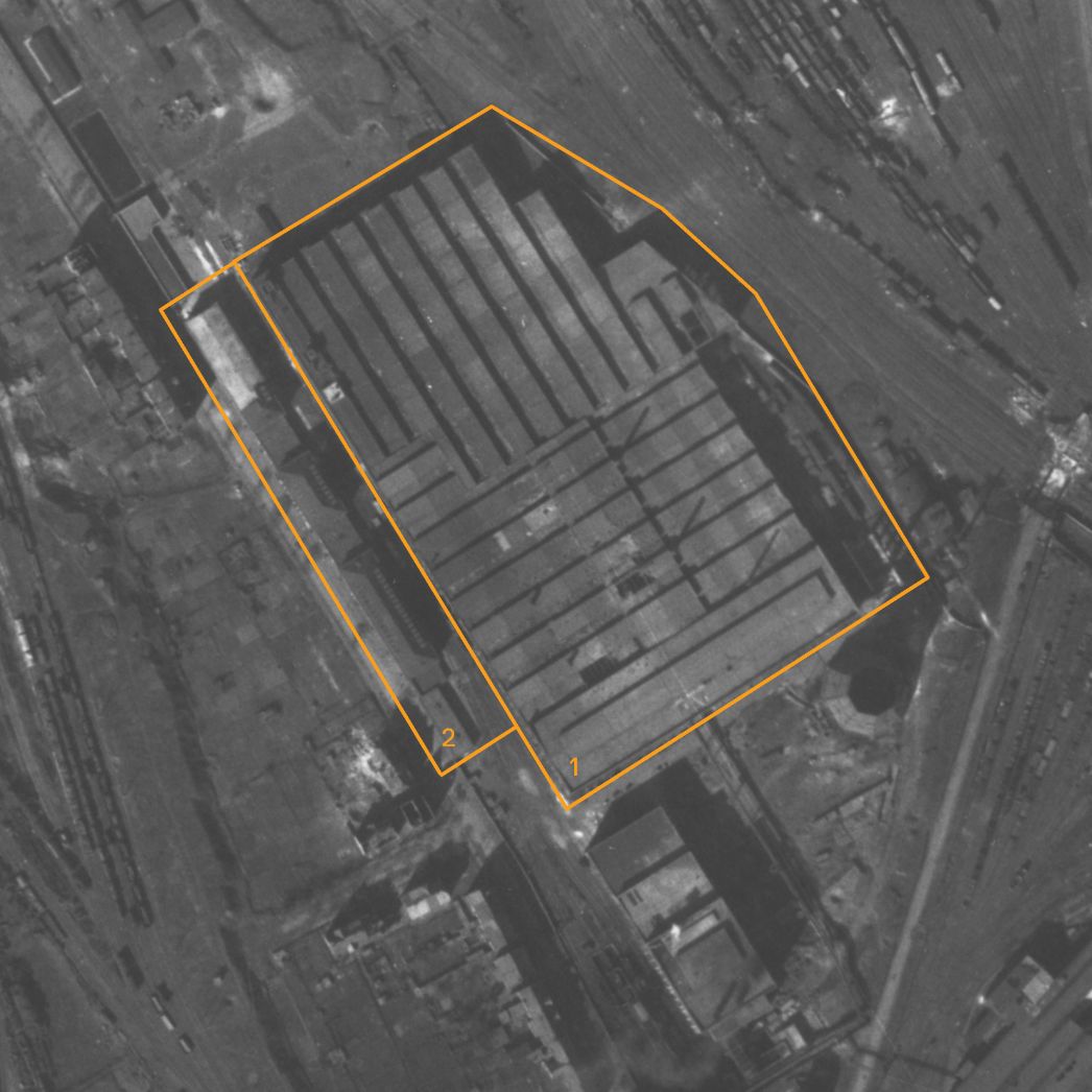 Vergrößerter Ausschnitt der Aufnahme der aliierten Luftaufklärung vom 25. März 1945. Markiert sind die Geschossfabrik (1) und die direkt daneben liegenden Häuser (2), von denen eines als Unterkunft für die KZ-Häftlinge genutzt wurde.
