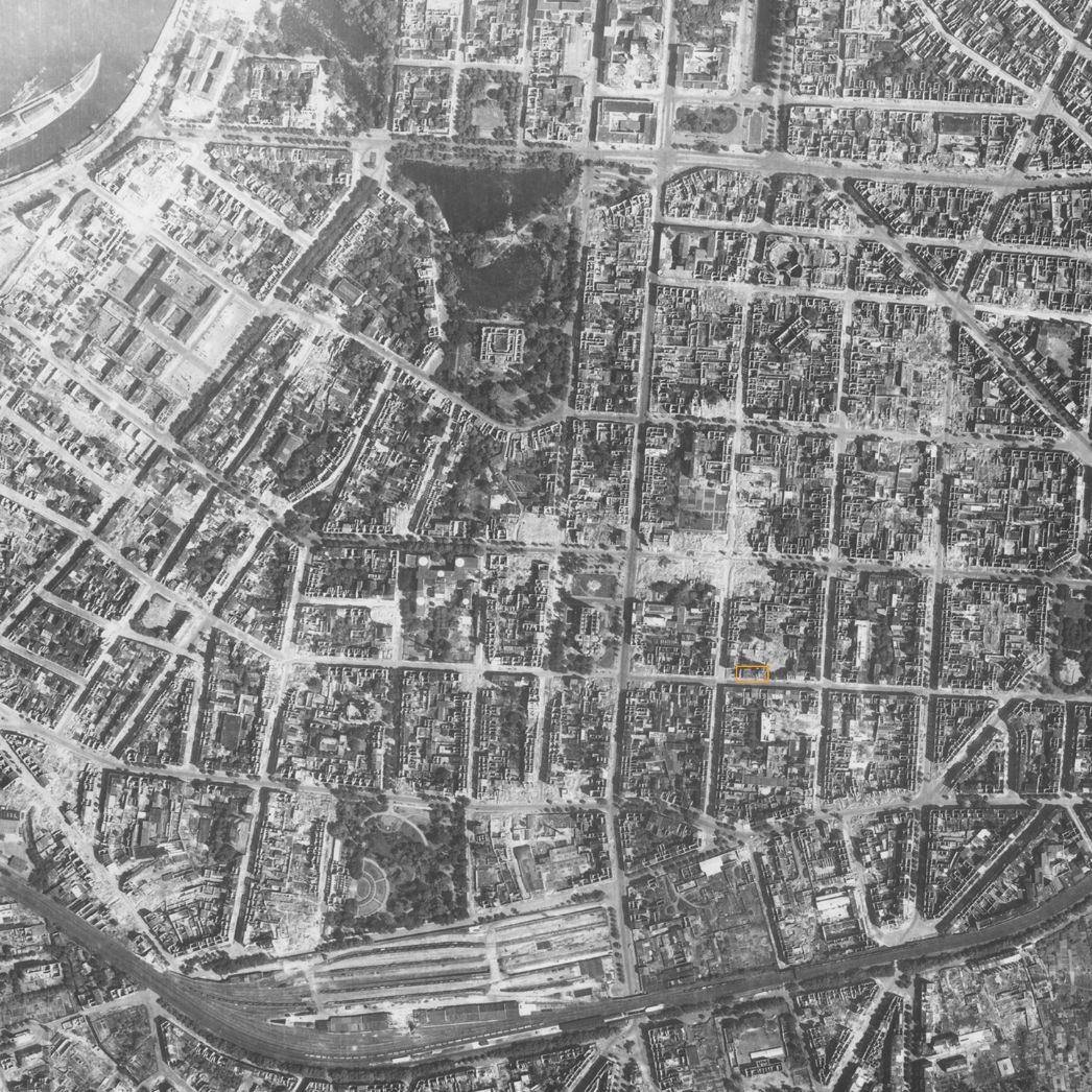 Düsseldorf, Stadtteil Friedrichstadt mit dem Bahnhof Düsseldorf-Bilk am unteren Bildrand. Aufnahme der alliierten Luftaufklärung, 19. Juni 1945 (Ausschnitt). Markiert ist das Schulgebäude in der Kirchfeldstraße, in dem die KZ-Häftlinge bis März 1945 untergebracht waren.
