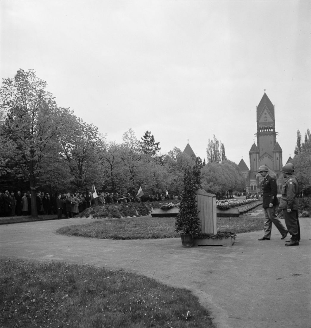 Beisetzung von 84 Opfern des Massakers von Abtnaundorf auf dem Südfriedhof in Leipzig, 27. April 1945. An der Zeremonie nahmen Angehörige der US-Army, Einheimische, befreite Zwangsarbeiterinnen und Zwangsarbeiter sowie ehemalige KZ-Häftlinge teil. Foto: Thérèse Bonney