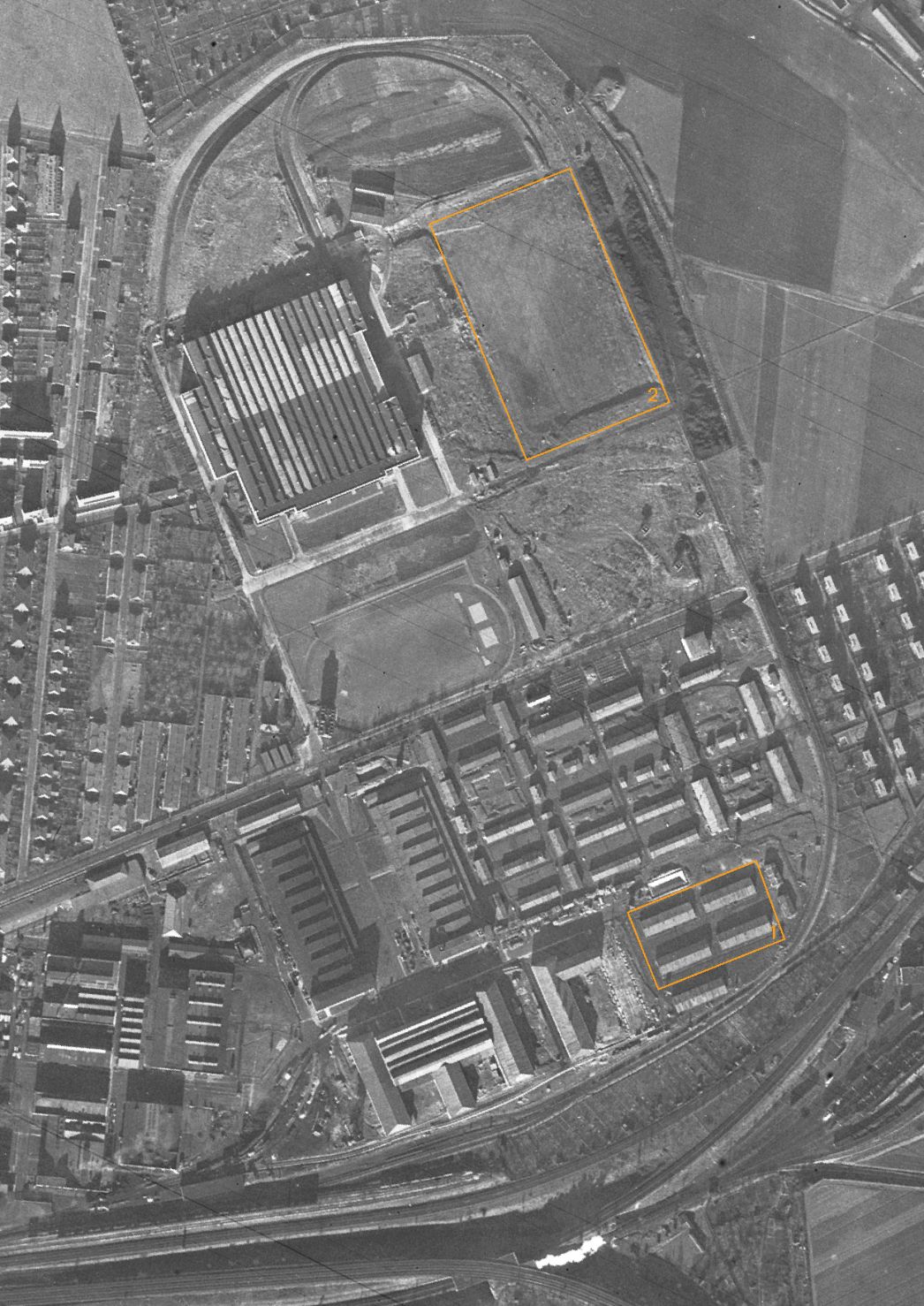 Das Areal des Fritz-Sauckel-Werks in Weimar mit angrenzenden Zwangsarbeiterlagern. Aufnahme der alliierten Luftaufklärung, 23. Dezember 1943 (Ausschnitt). Markiert sind der Standort des ersten Barackenlagers (1) sowie das Gelände, wo im Herbst 1944 ein zweites Barackenlager für KZ-Häftlinge entstand (2).